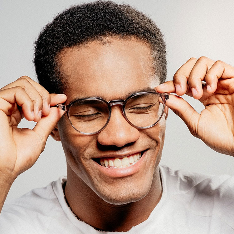 Black man smiling while wearing glasses